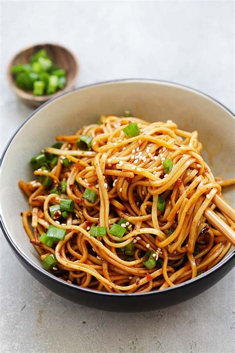 Easy and delicious spicy Chinese Sichuan cold dry noodles topped with sesame seeds and chopped ...