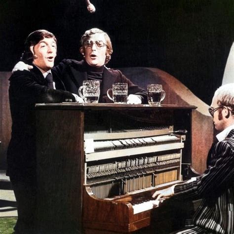 two men are sitting at a piano and one man is playing the organ while ...