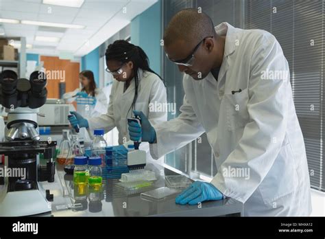 Scientists doing experiment in lab Stock Photo - Alamy