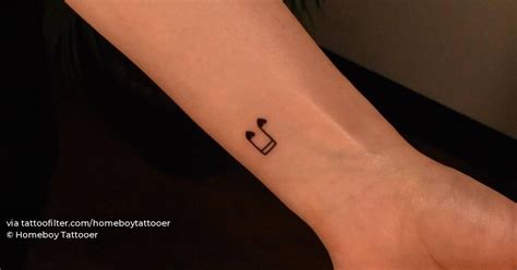 Minimalistic quaver note tattoo located on the wrist.