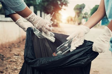 Premium Photo | Mother and child help picking up trash at park