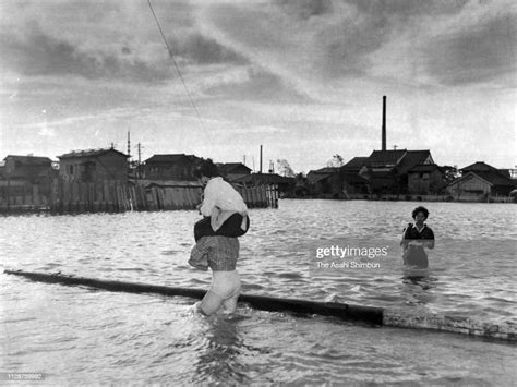 People walk in a flooded road as Typhoon Vera, aka Isewan Typhoon ...