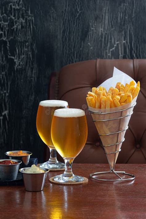 French Fries in Cone with Two Belgian Beers and Dipping Sauces Stock ...