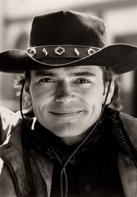 a black and white photo of a man wearing a cowboy hat