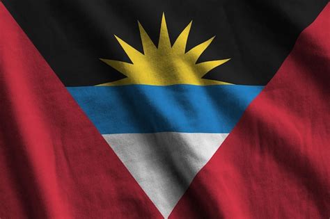 Premium Photo | Antigua and barbuda flag with big folds waving close up under the studio light ...