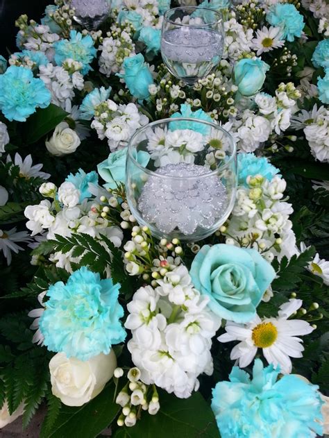 the centerpieces are arranged neatly on the table, with flowers and ice cubes in them