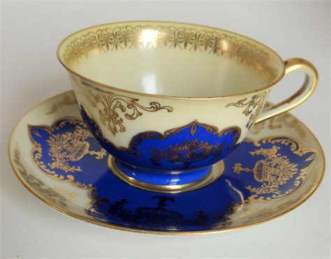 a blue and gold tea cup on a saucer