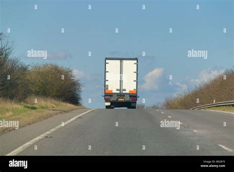 A heavy goods lorry disappearing over the brow of a hill Stock Photo - Alamy