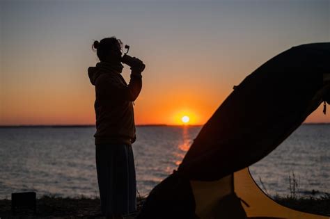 Premium Photo | Side view of woman holding hands against sea during sunset