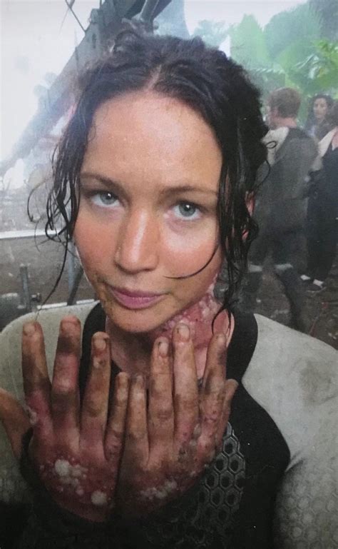 a woman with mud on her face and hands