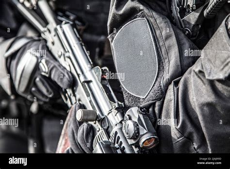 SWAT team members armed with service rifles, standing in stack formation during a suspect arrest ...