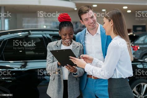 Smiling Young Couple Undersign A Car Contract At New Car Showroom Stock Photo - Download Image ...