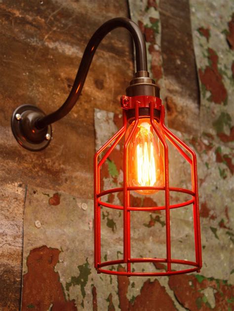 Industrial wall light with antique brass arm and red metal wire cage. Bespoke Lighting, Lighting ...