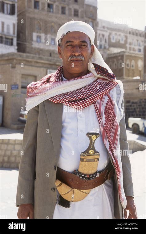 Yemen, Sana'a Yemeni man near Bab Al Sabah, in traditional dress, with coat, head cover and ...