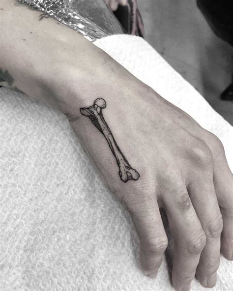 Little bone tattoo on the hand - Tattoogrid.net