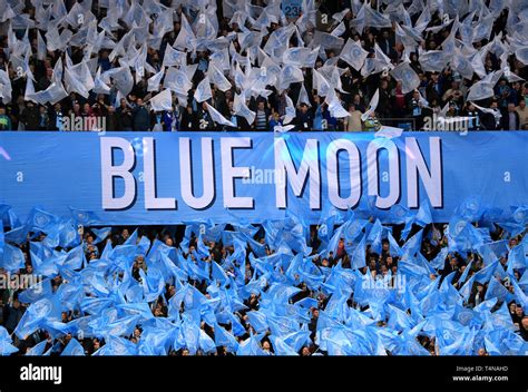 Manchester City fans wave flags ahead of kick-off near a banner that ...