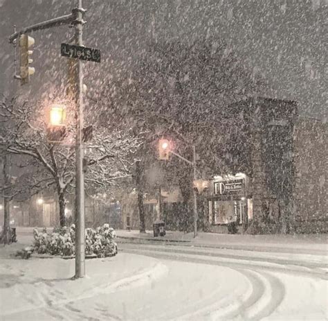 Download A Snow Covered Street With A Street Light | Wallpapers.com