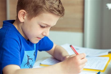 Premium Photo | Close-up of boy writing homework on table