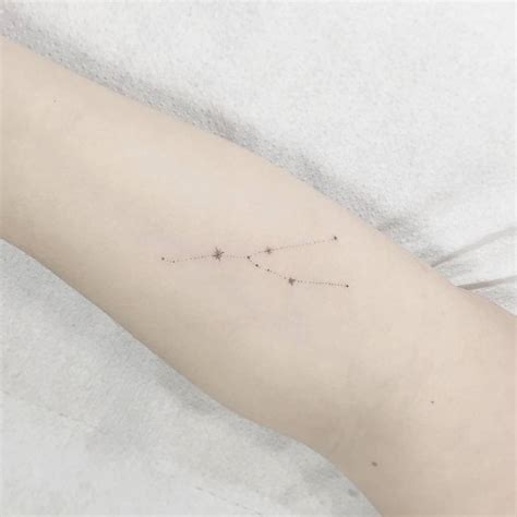 Taurus constellation tattoo on the inner forearm.