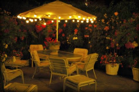 Lit Umbrella, white patio table and chairs, flowering plan… | Flickr
