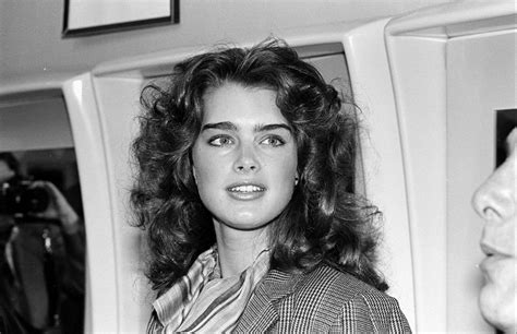 a black and white photo of a woman with long hair in an airplane cabin ...