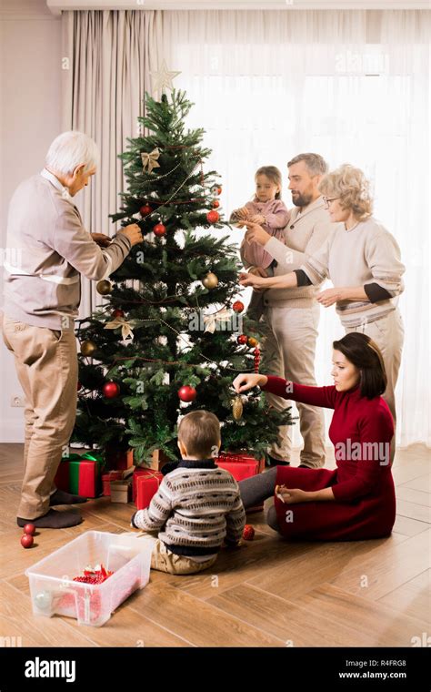 Happy Family Decorating Christmas Tree Stock Photo - Alamy