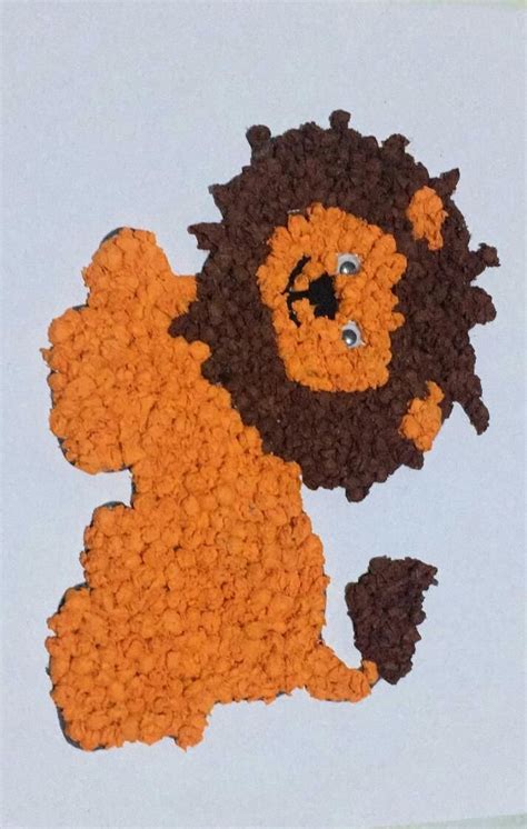 a crocheted lion is sitting on the ground