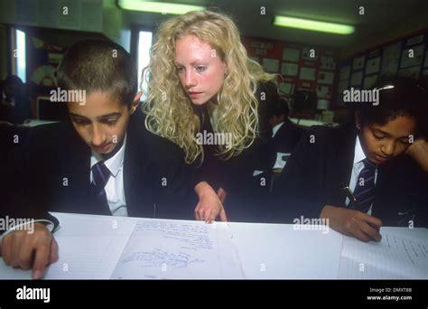 Teacher assisting secondary school pupil in classroom, Heathland School ...