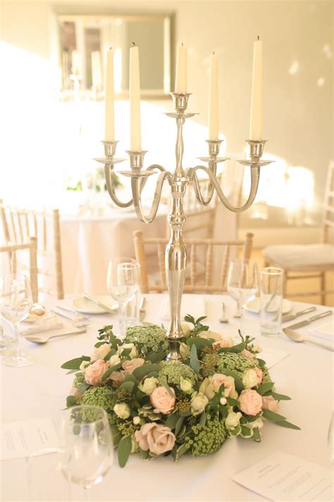 Small wreath style arrangement of flowers around the base of the candelabra. | Candelabra ...