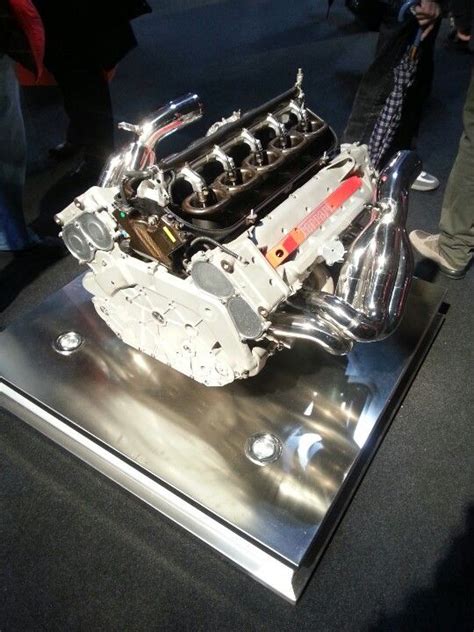 an engine is on display in a showroom while people look at it from the side