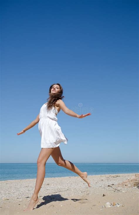 Barefoot Girl in White Dress Skips on Sand Seashore Stock Photo - Image ...