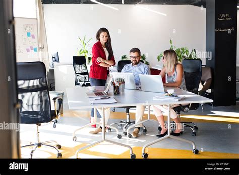 Three business people in the office talking together Stock Photo - Alamy