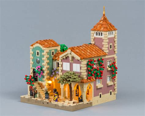a lego model of a building with flowers on the windows and people standing outside it