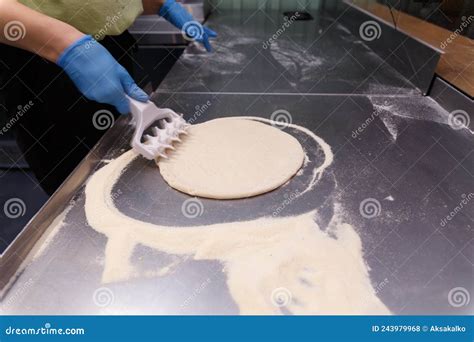 The Cook Processes the Pizza Dough with a Special Roller with Spikes Stock Photo - Image of ...