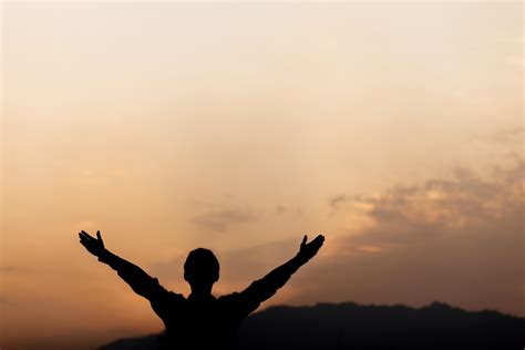 Silhouette of a man lift hands up and prayer at sunset. concept of ...