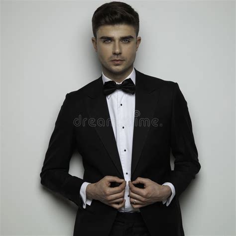 Relaxed Elegant Man with Undone Bowtie Standing Cross-legged Stock ...