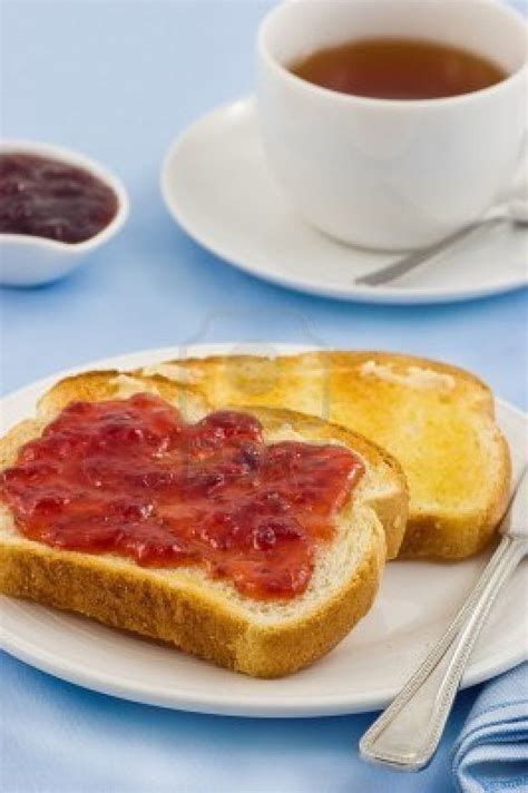 Fresh buttered toast with strawberry jam and tea on blue background ...