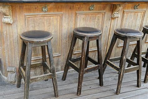 Old fashioned bar stools | Vintage and rustic wooden bar stools on wooden floor in front of ...