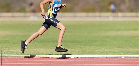 Child running in stadium. Kids run on outdoor track. Young athlete training. Jogging for kid ...