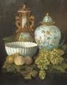 Peaches, grapes, a pear, a porcelain bowl and oriental vases on a ...