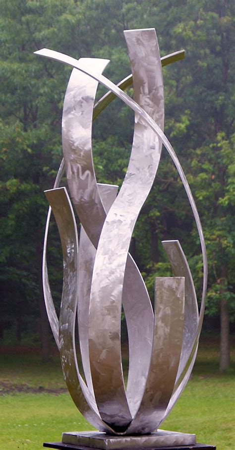 a large metal sculpture sitting on top of a lush green field