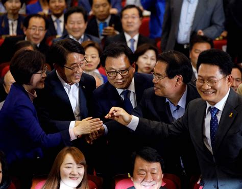 Party leaders and members of the Democratic Party of Korea react as ...