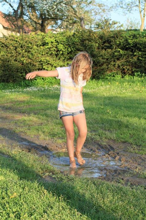 Little Girl In Muddy Puddle Stock Image - Image: 30875315