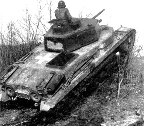 an old tank that is sitting in the dirt and mud, with a man on top of it