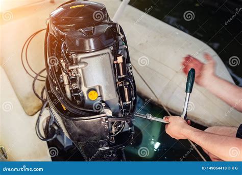 Mechanic Repairing Inflatable Motorboat Engine at Boat Garage. Ship Engine Seasonal Service and ...