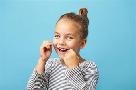 Premium Photo | Dental flush caucasian child girl using flossing teeth ...