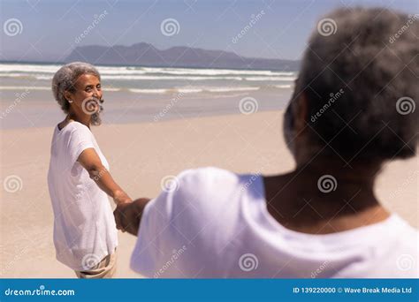 Senior Couple Holding Hands on Beach Stock Photo - Image of carefree ...