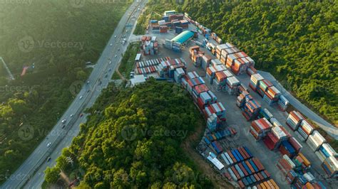 The Cargo Container yard next the road and surrounded by mountains , forklift truck and cargo at ...