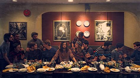 a group of people sitting at a table with plates and food in front of them