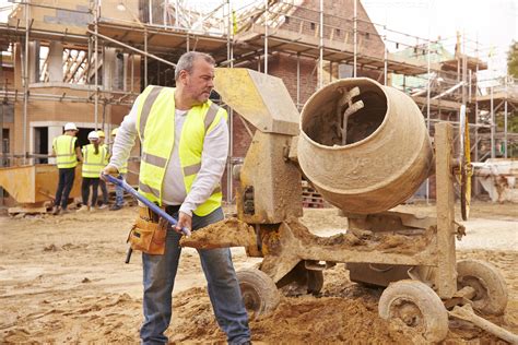 Construction Worker On Building Site Mixing Cement 903398 Stock Photo at Vecteezy